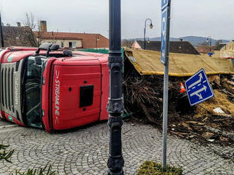 Následky dopravní nehody kamionu odstraňují hasiči v Bělčicích na náměstí. Kamion převážel dřevní…