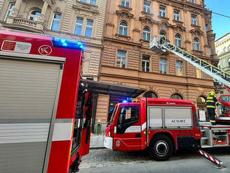 V ulici Myslíkova v Praze zasahují hasiči u požáru na balkoně. Používají výškovou techniku.